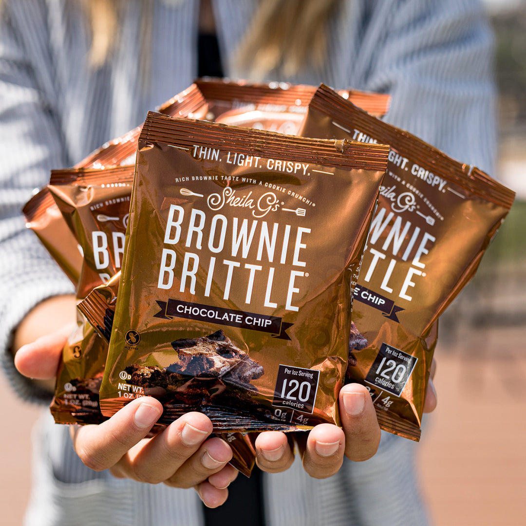 Holding bags of Chocolate Chip Brownie Brittle - 2.75oz (8 ct. box)